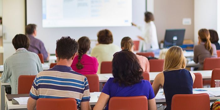 Grupo de personas asistiendo a una conferencia educativa sobre la consulta pública de los Criterios y Directrices para el Aseguramiento de la Calidad en el Espacio Europeo de Educación Superior.