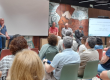 Vista general de la mesa redonda durante la jornada sobre acreditación institucional en la UPV, con los ponentes hablando frente al público en el Aula Espai-Natura.
