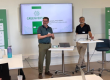 Luis Miguel Martínez y Javier Oliver Villarroya, representantes de AVAP, imparten la sesión sobre el GREENVERSITY University Pathway en una sala de la Université Bourgogne Europe, con pantallas y carteles corporativos del proyecto de sostenibilidad detrás.