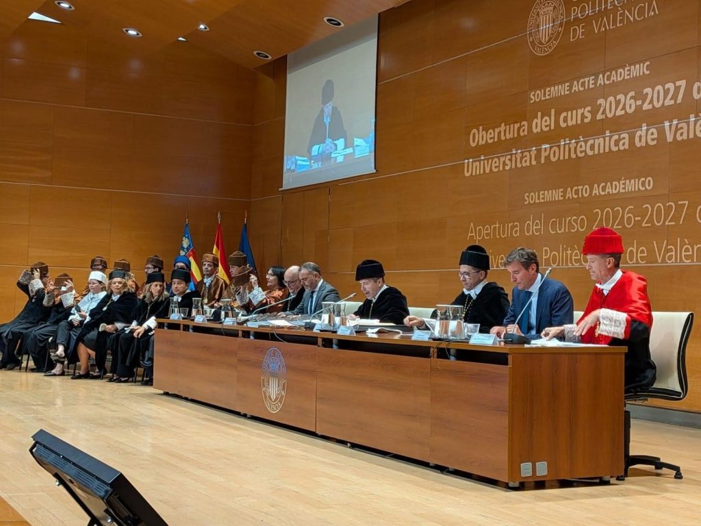 Mesa presidencial con autoridades académicas e institucionales en el Solemne Acto de Apertura del Curso Académico 2026-2027 de la Universitat Politècnica de València en el Paraninfo del campus de Vera, con fondo de pared de madera e inscripciones oficiales.