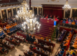 Vista panorámica del Paraninfo de La Nau durante el Solemne Acto de Apertura del Curso Académico de la Universitat de València, con autoridades en la mesa presidencial y académicos vestidos con birretes y togas de colores en los asientos.